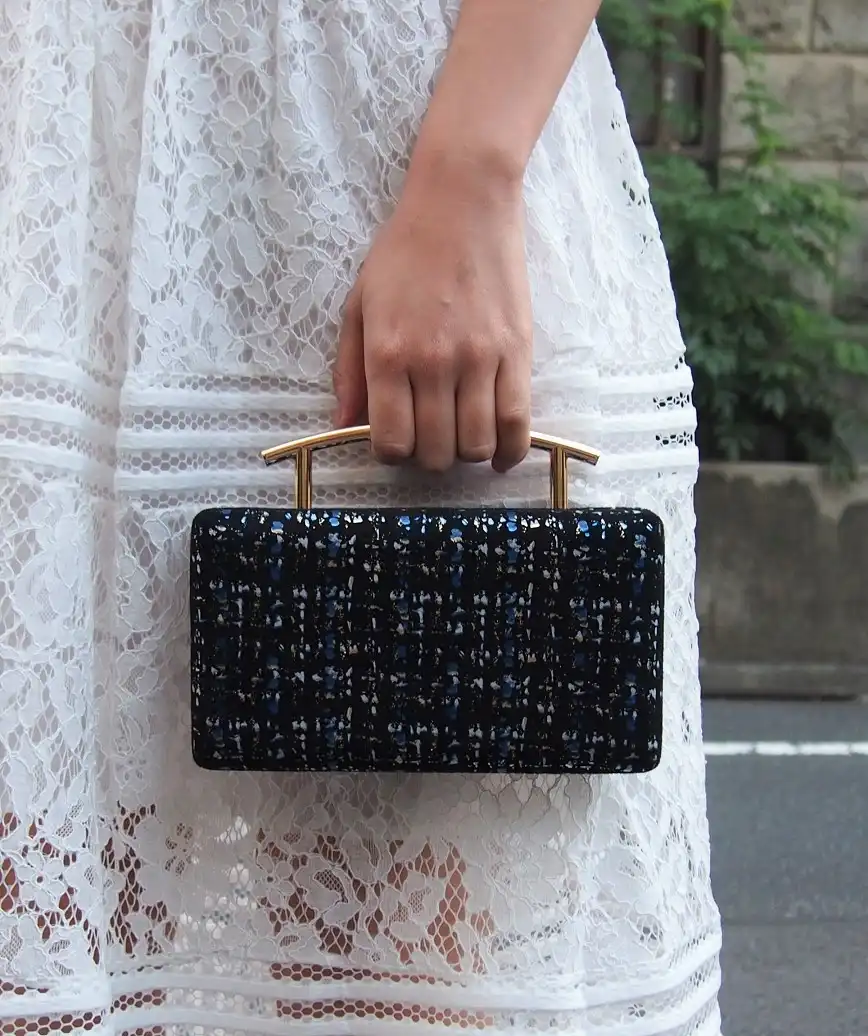 Tweed like handle clutch bag